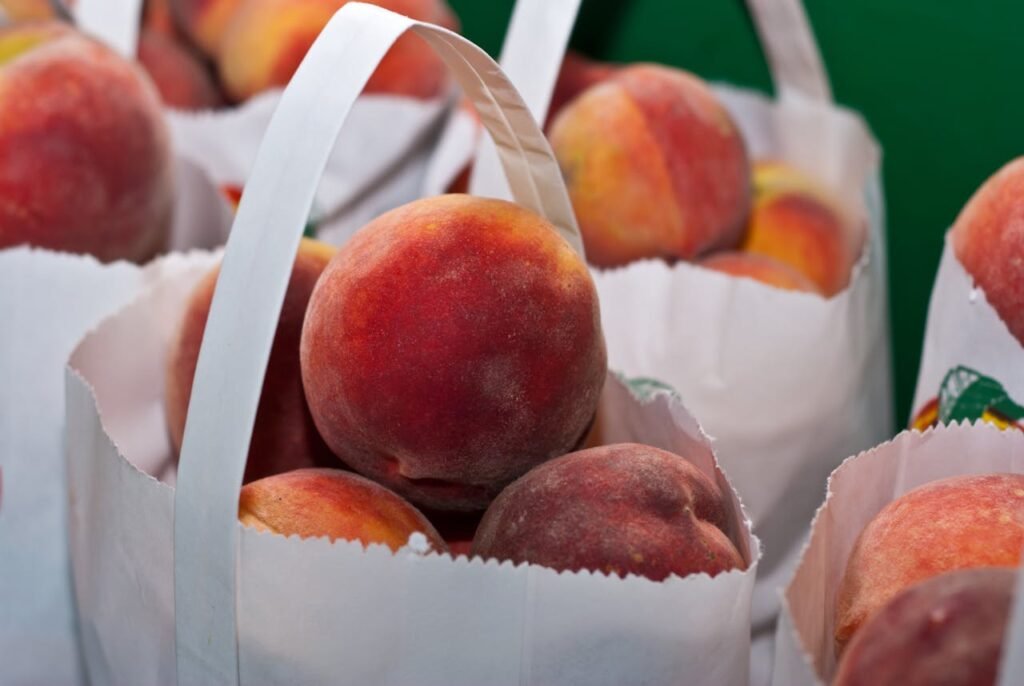 Ripe, juicy peaches in paper bags, highlighting freshness and healthy eating.